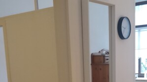 Una habitación con cama, una silla, un escritorio y un espejo en la pared.