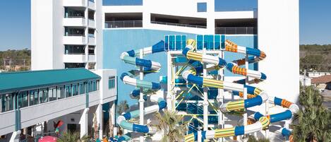 A water park with multiple slides and a building with balconies.