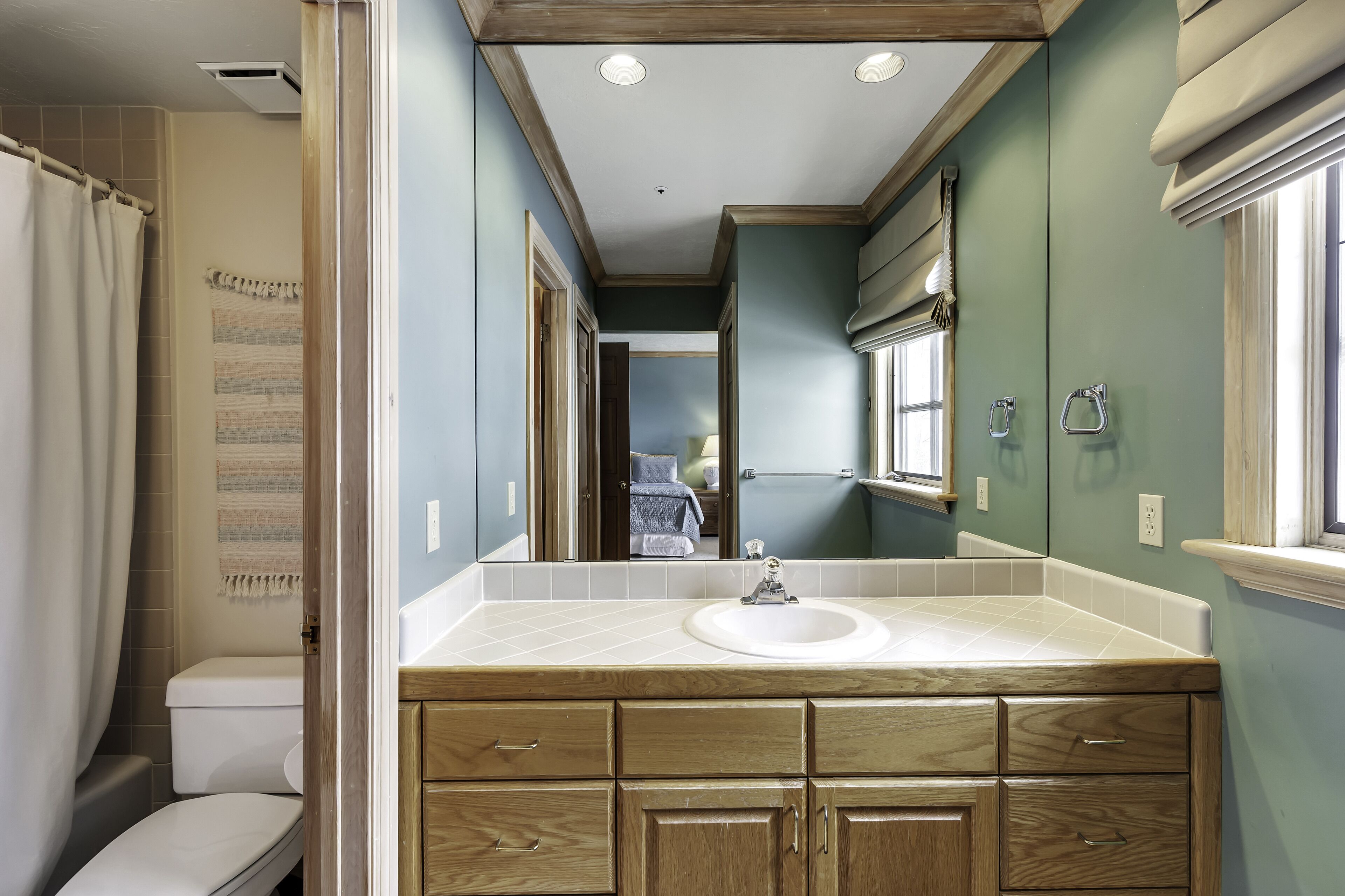 Une salle de bain avec un meuble-lavabo en bois, un évier et un miroir.