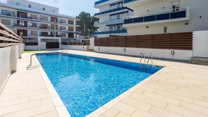 Una piscina rodeada de modernos edificios de apartamentos con balcones.