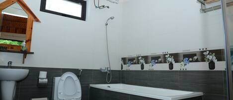 Une salle de bain comprenant des toilettes, un lavabo, une douche et une baignoire.