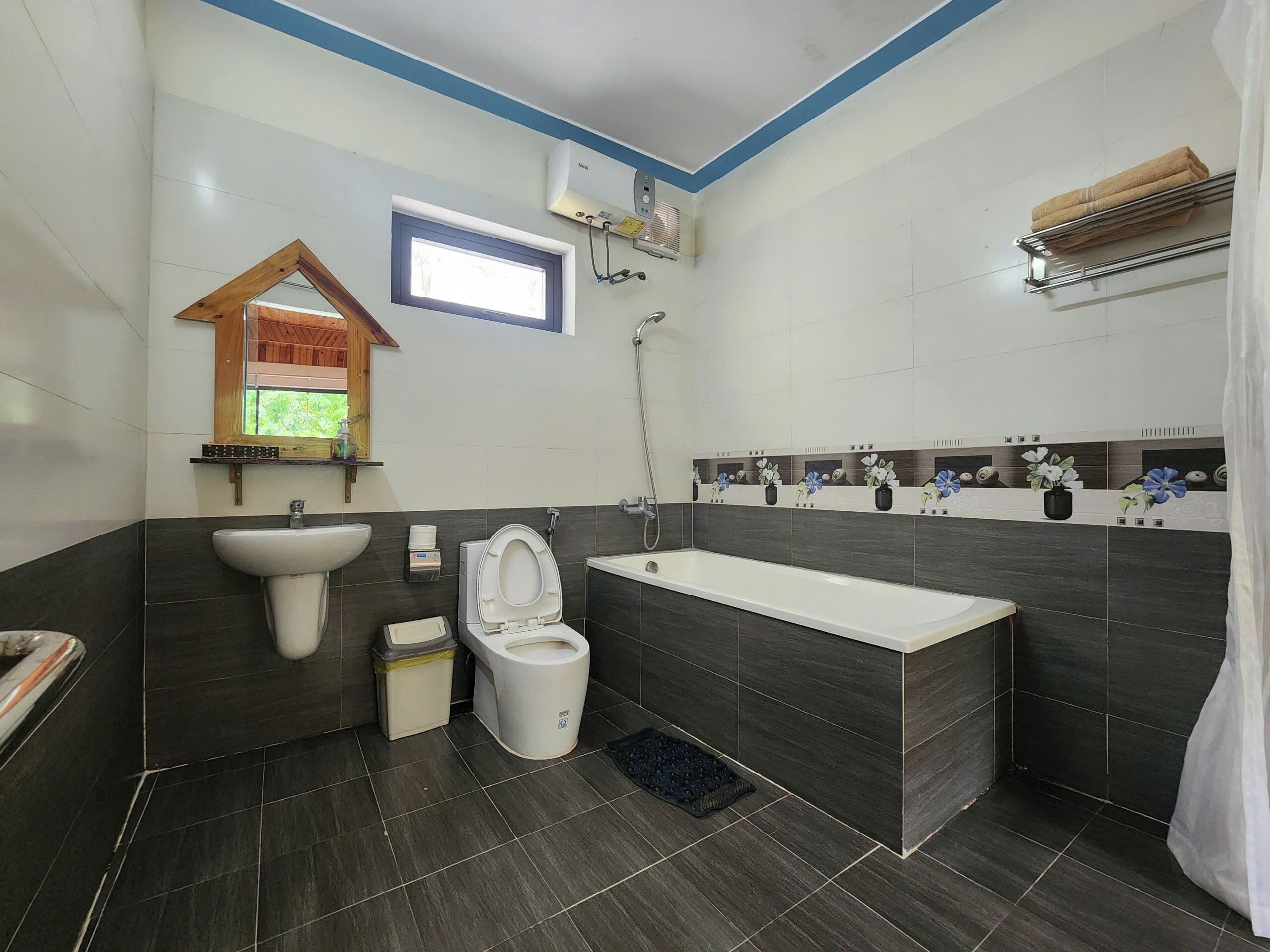 Een moderne badkamer met toilet, wastafel en bad.