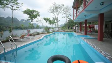 A swimming pool with lounge chairs and a view of the mountains.