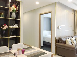 A modern hotel room with a dining area, a sofa, and a bed. - Saffron Casa (Ho Chi Minh City)