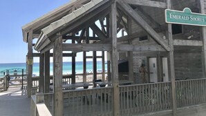 A wooden beach pavilion with a sign reading "Emerald Shores".