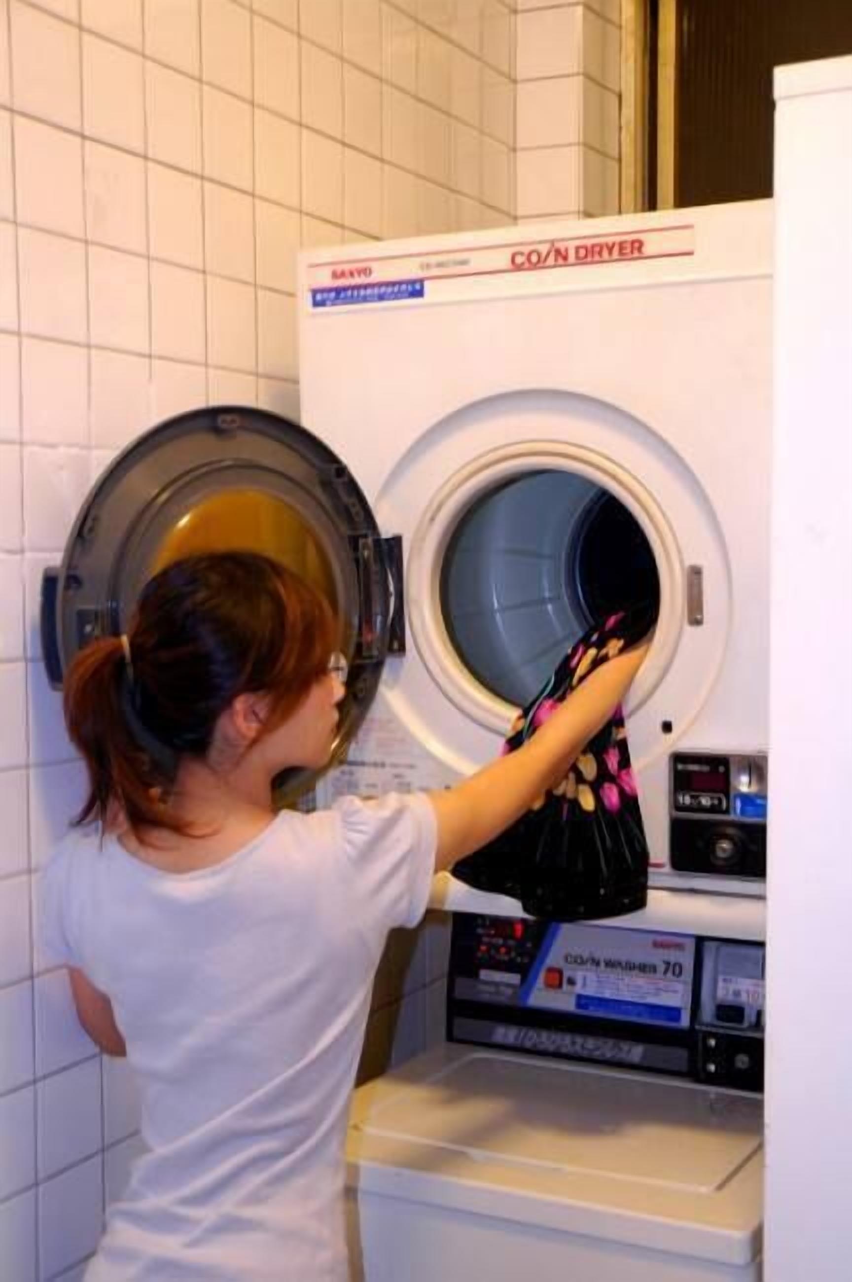Una persona cargando una lavadora con un tejido estampado.