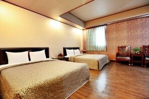 A hotel room with two beds, a wooden floor, a large window with curtains, and a decorative chair. - Hotel Lee - Chan (Taipei)