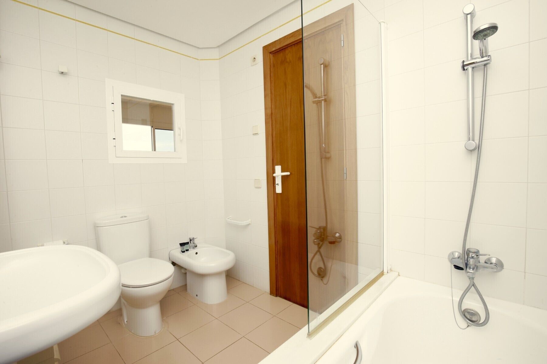 Un baño con inodoro, bidé y bañera.