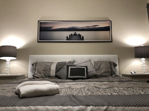 A neatly made bed with patterned bedding, a framed artwork above it, and two bedside lamps on either side. - Gated Reunion Resort Luxury Condo w/Balcony Golf Course view-6 miles to Disney (Kissimmee)