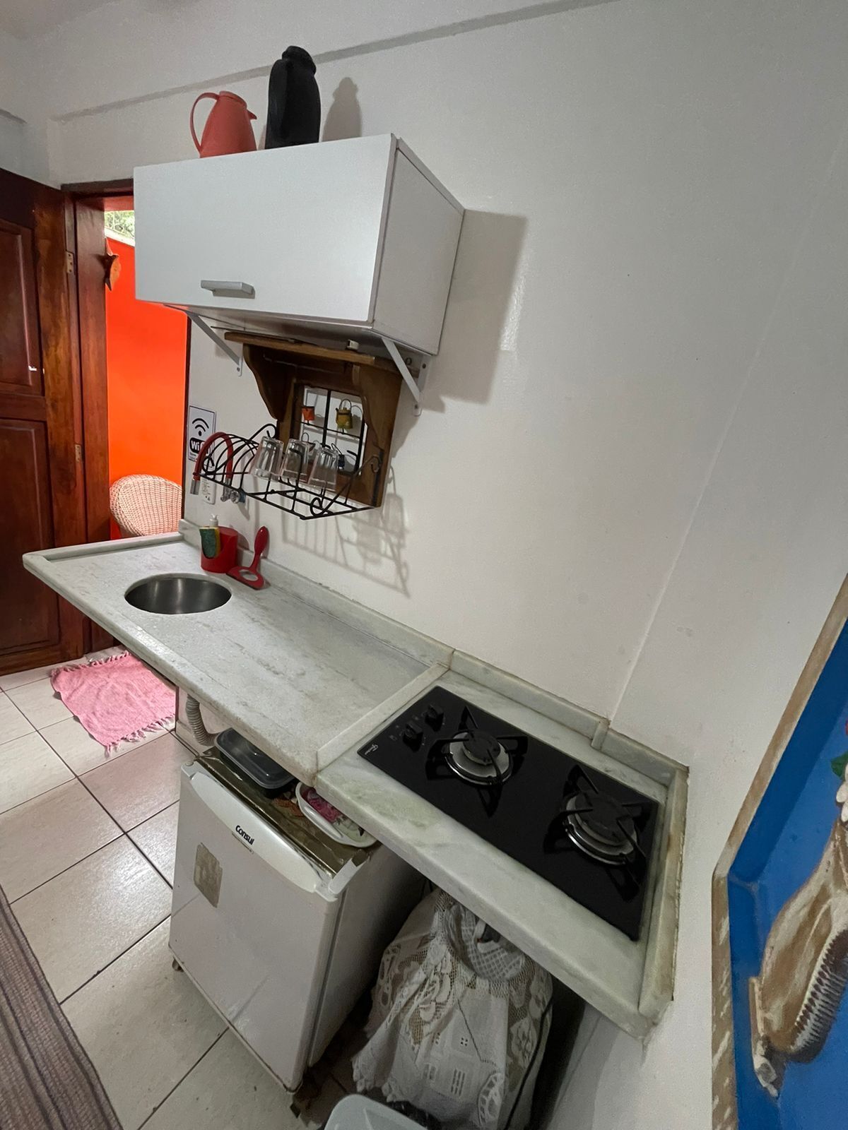 A compact kitchen with a sink, stove, and a small refrigerator.
