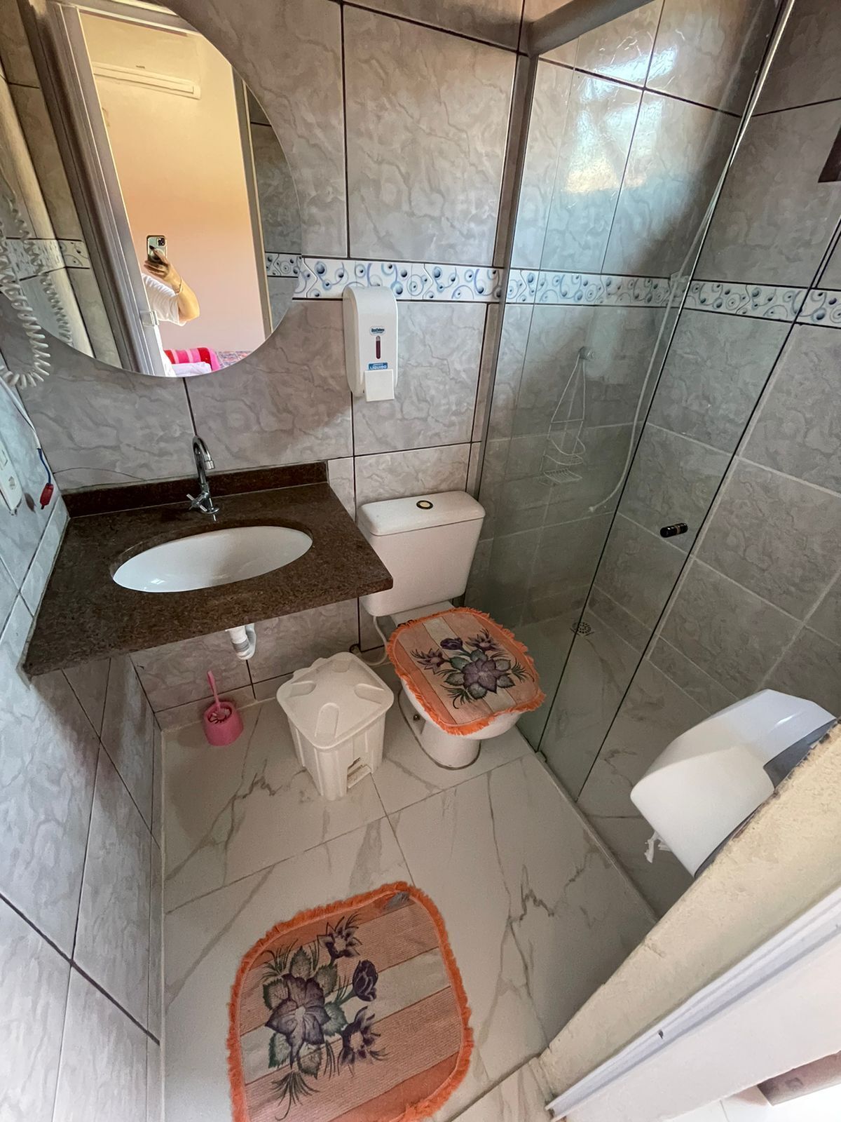 Un baño con lavamanos, inodoro y ducha de mármol.
