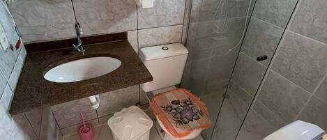 Un baño con lavamanos, inodoro y ducha de mármol.
