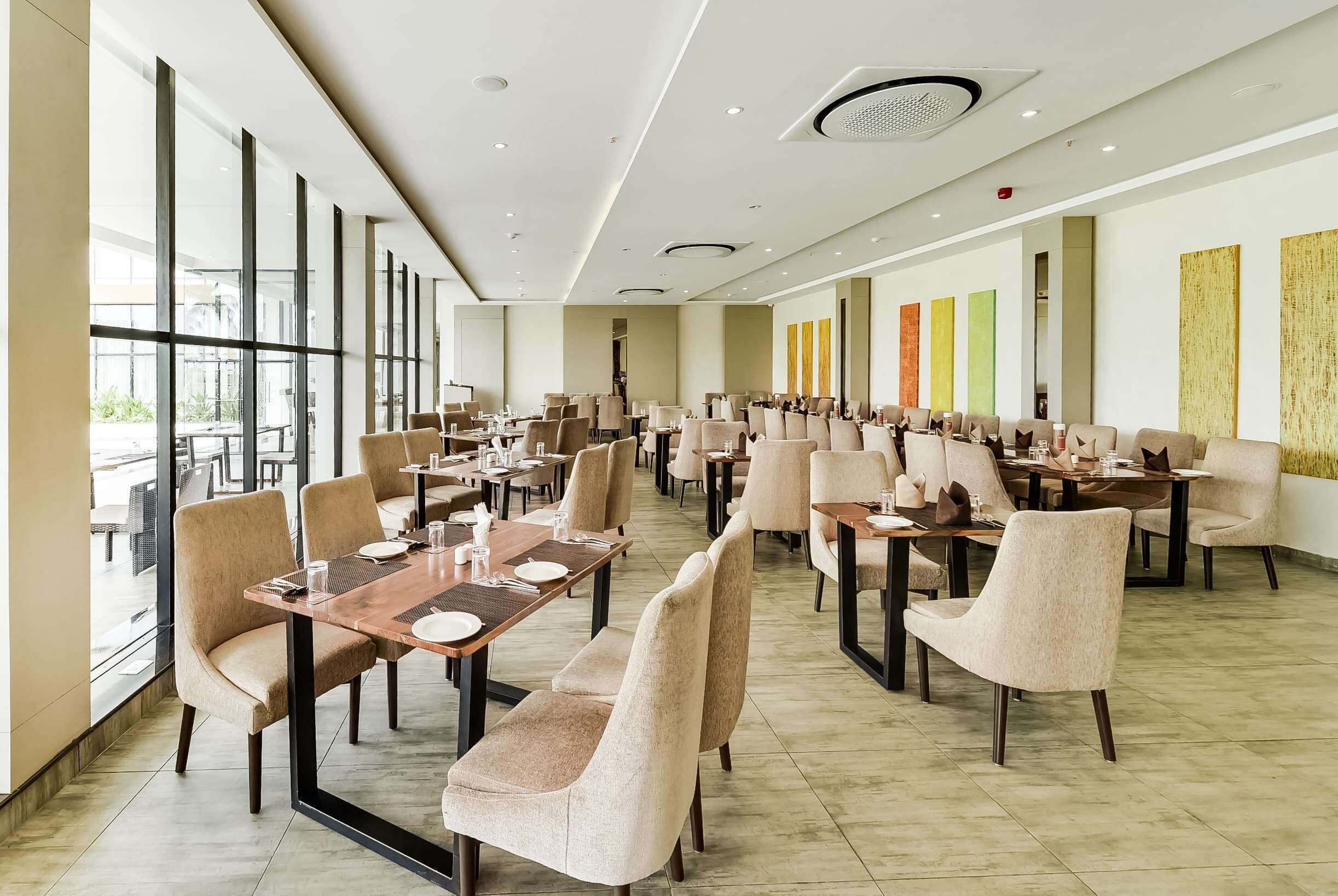 A spacious restaurant with high ceilings, large windows, and modern decor.