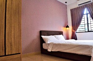 Ein Schlafzimmer mit einem Bett, einem Nachttisch, einer Wandlampe und einem Fenster mit Vorhängen.