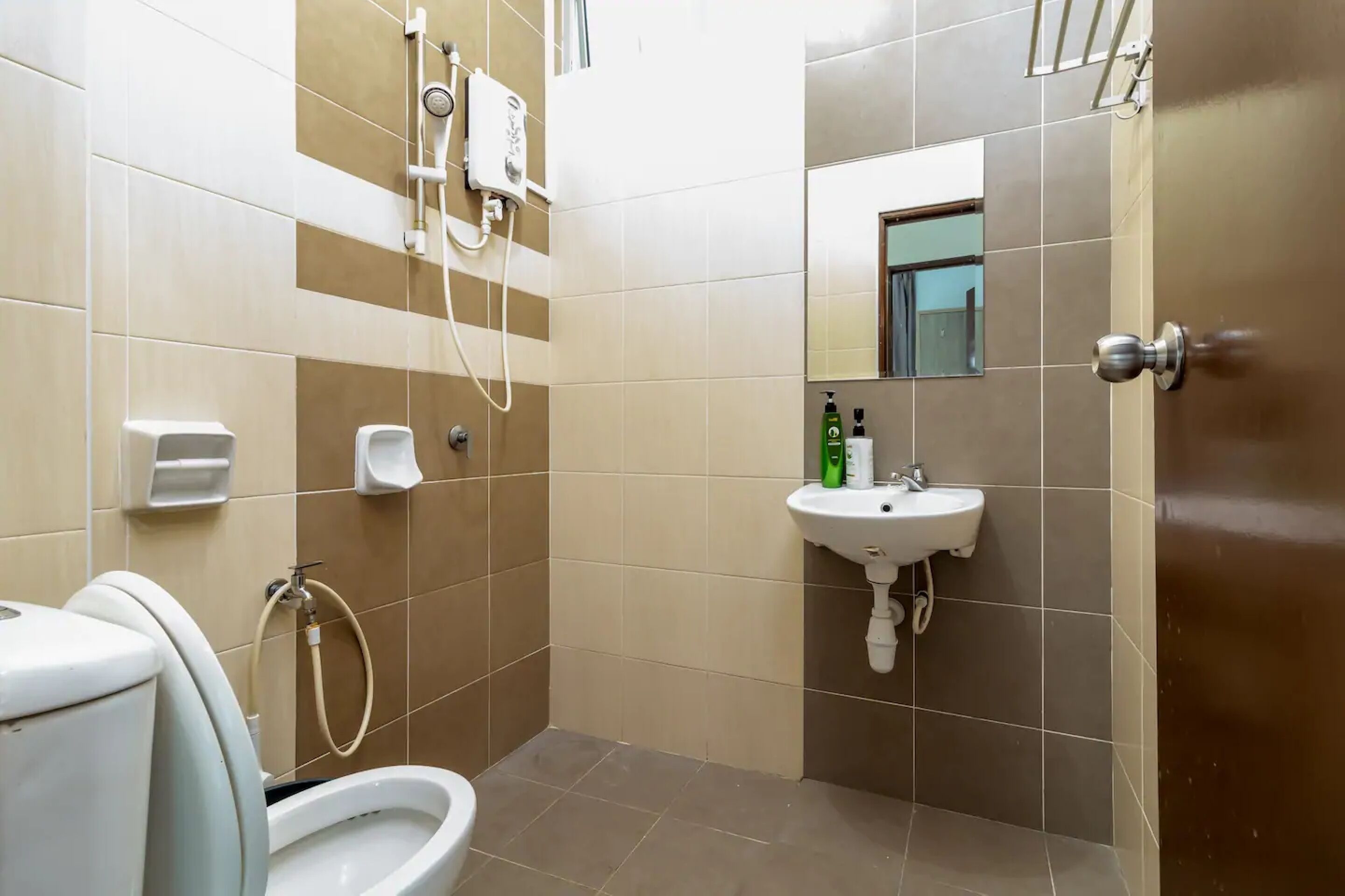 A bathroom with a toilet, bidet, sink, and a mirror.