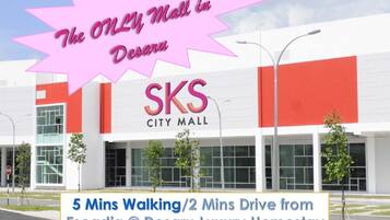 La façade du centre commercial SKS City Mall à Desaru, avec une enseigne indiquant qu’il se trouve à 5 minutes à pied ou à 2 minutes en voiture de l’établissement Escadia @ Desaru Luxury Homestay.