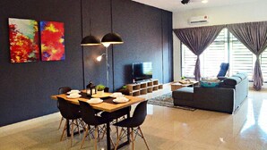 Una sala moderna con comedor, televisor de pantalla plana y sofá.