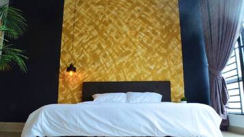 A bed with white bedding, a dark headboard, and a patterned wall behind it.