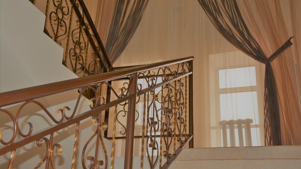 A staircase with ornate metal railings and a view of the interior.