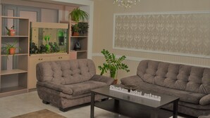 A living room with two grey sofas, a coffee table, a fish tank, and a chandelier.