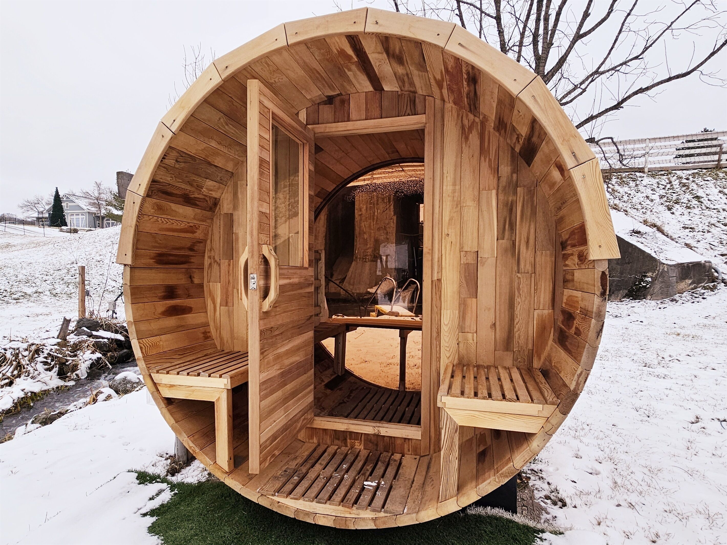 Une structure de sauna en bois, avec deux bancs et une table à l’intérieur.