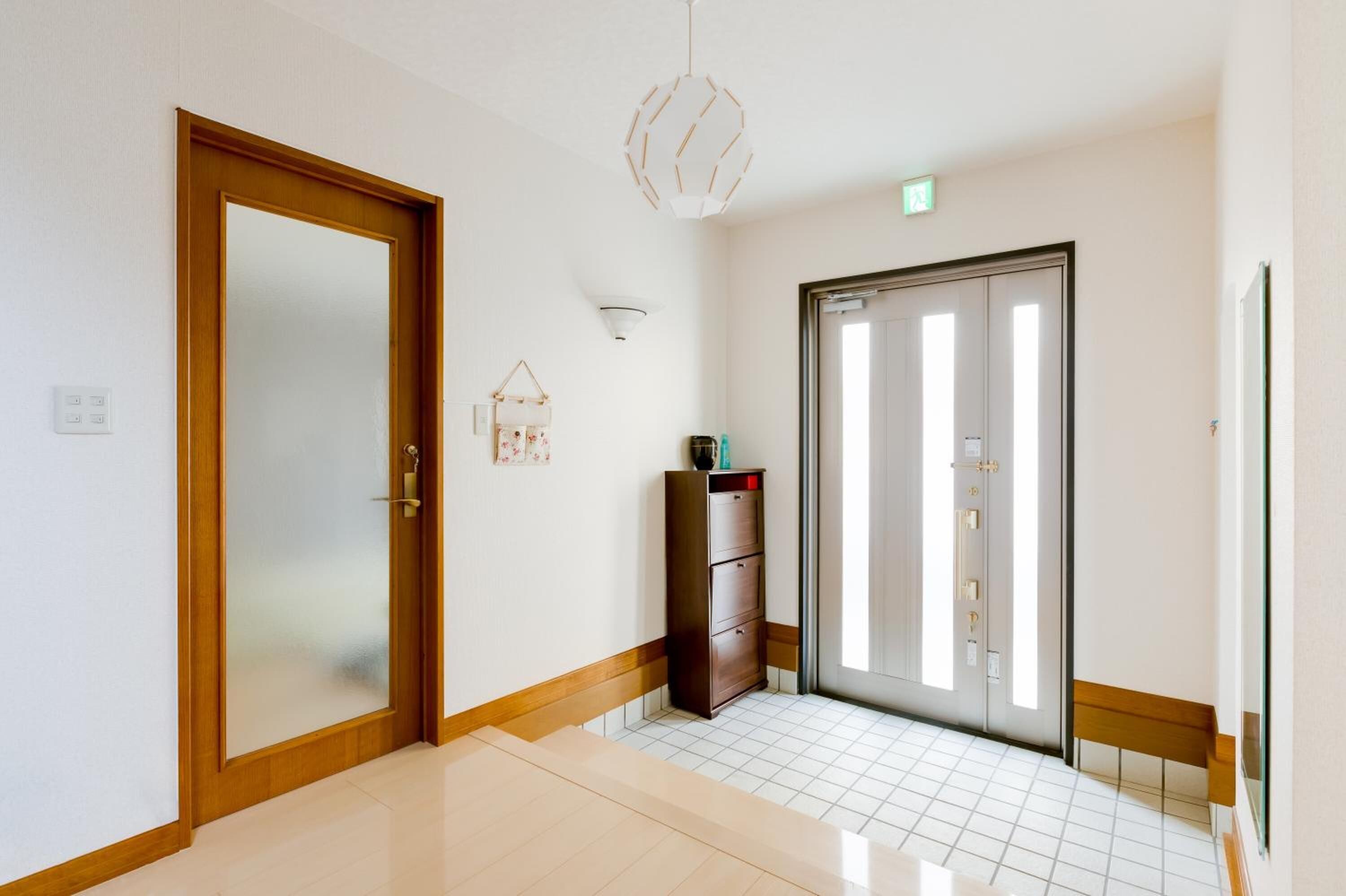A hotel hallway with a wooden door, a cabinet, and a bench.