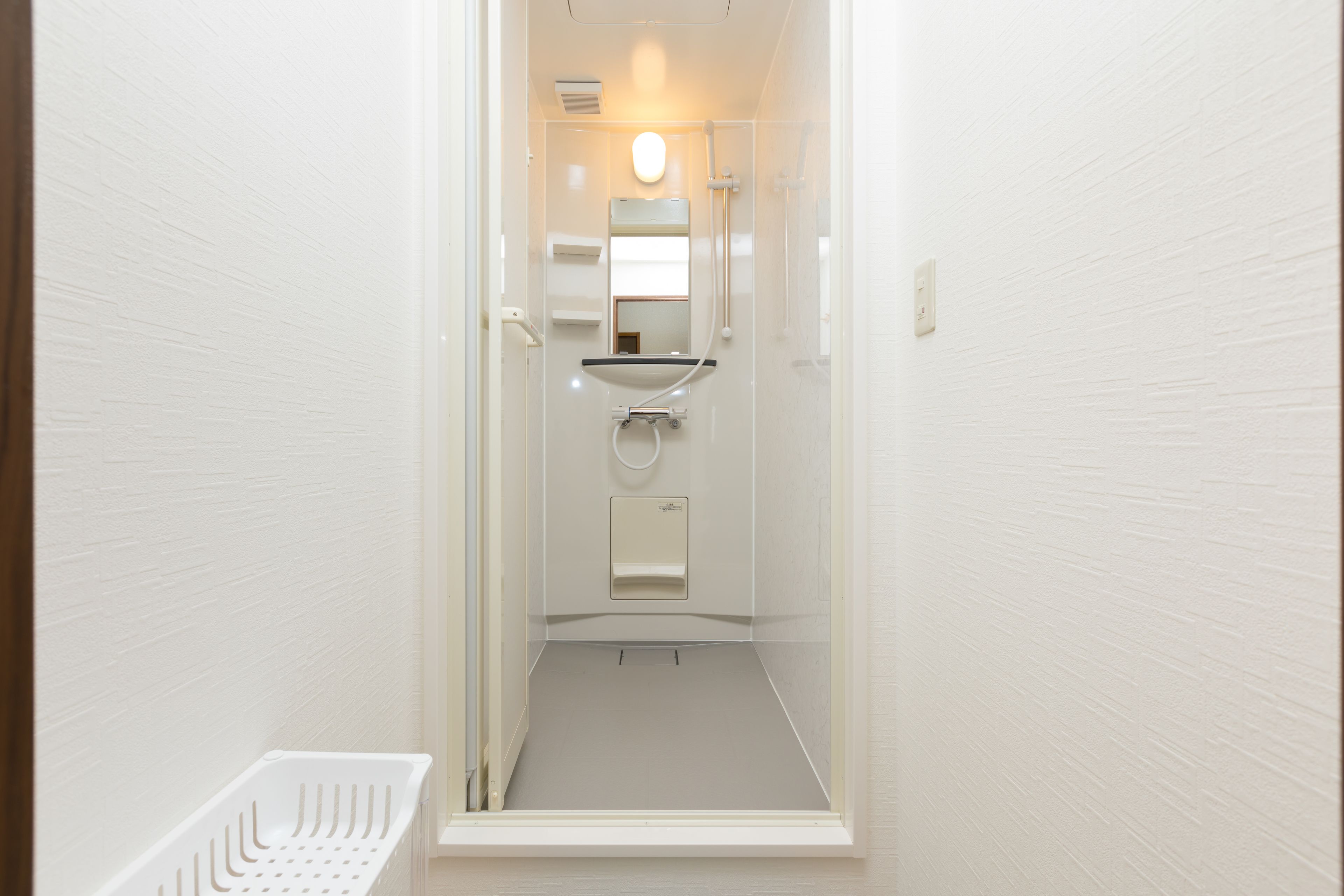Een douche, een regendouche, pantoffels, handdoeken