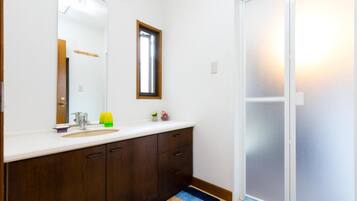 A bathroom with a white sink, dark wooden cabinets, a mirror, and a blue rug.