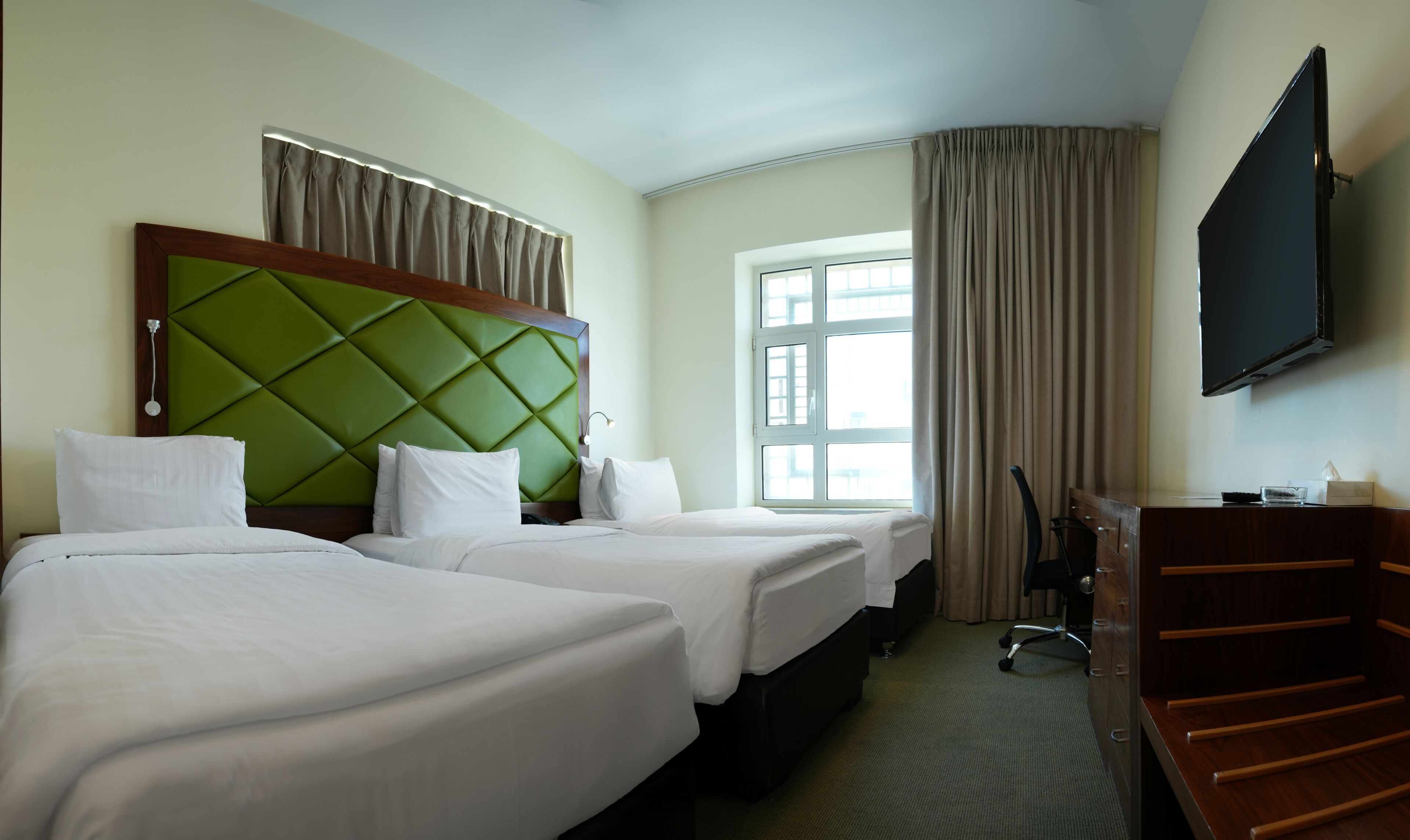 Deluxe Triple Room | Minibar, desk, laptop workspace, blackout drapes