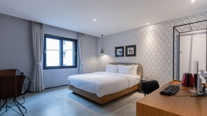 Una habitación de hotel moderna con cama, escritorio y silla.