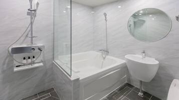 Ein modernes Badezimmer mit einer gläsernen Duschkabine, einer freistehenden Badewanne und einem Standwaschbecken.