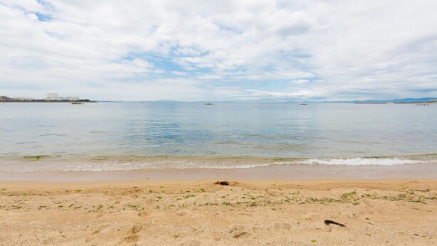 A beach with a clear sky and calm sea. - A&Z guesthouse (Kaizuka)