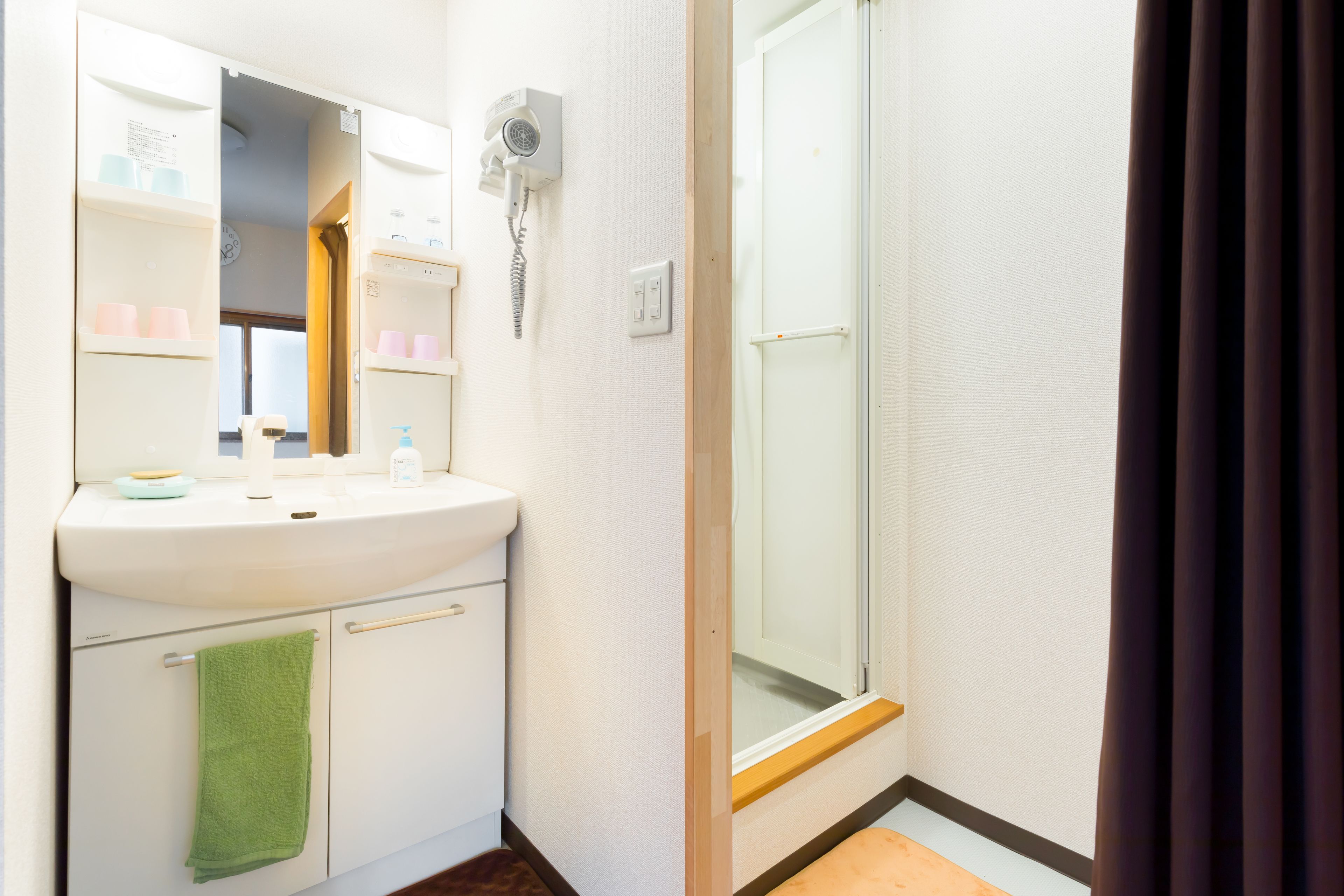 Un baño con lavabo, espejo y zona de ducha.