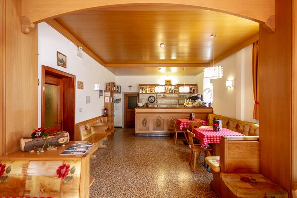 Un interior acogedor y rústico con muebles de madera, una zona de cocina y un comedor.