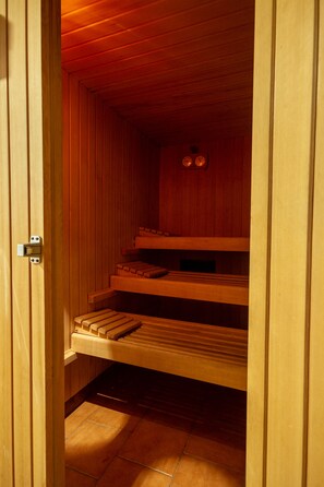 Una sauna con bancos de madera y un reloj en la pared.