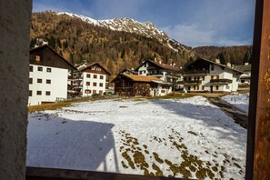 Un pueblo cubierto de nieve con casas de madera tradicionales y una montaña al fondo.