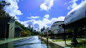 A street with a parked RV and a building with a covered porch. - Beach Resorts Hotel KALAKAUA (Onna)