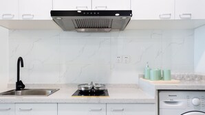 Une cuisine moderne dotée d’un évier en acier inoxydable, d’une cuisinière encastrée et d’un lave-vaisselle.