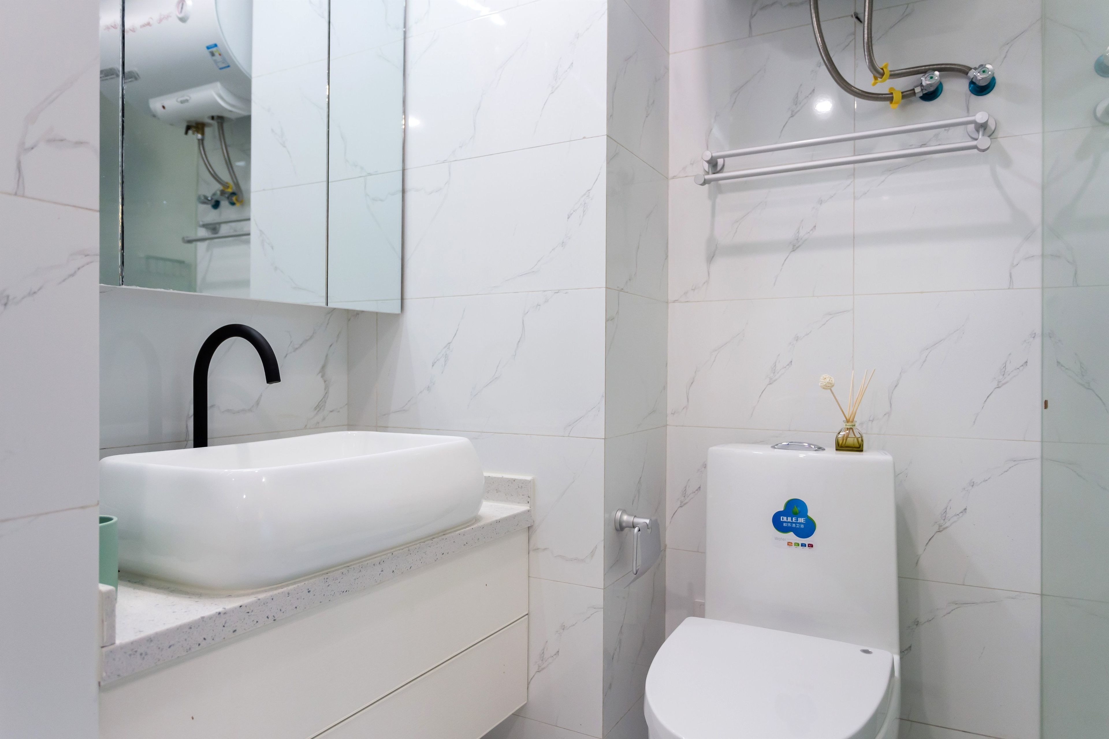 A bathroom with a white sink, a mirror, and a toilet.