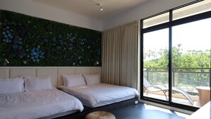 A modern bedroom with two beds, a green floral wall, a large window with a view of greenery, and a balcony with wicker furniture. - Song Qian Brigade (Lukang)