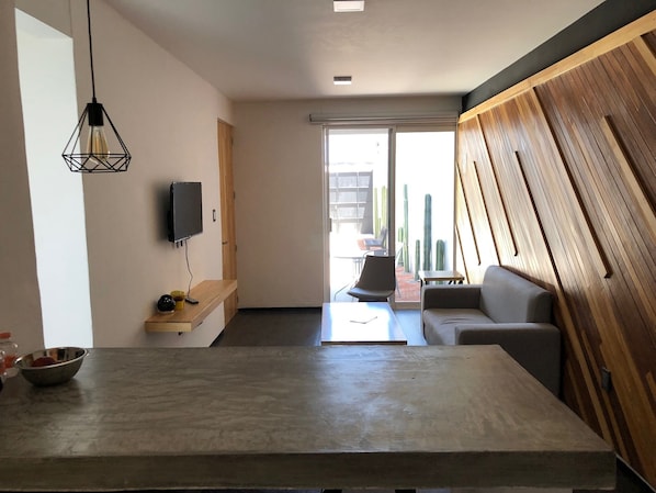Relax in a spacious room with a large flat-screen TV, comfortable seating area, and a unique accent wall.