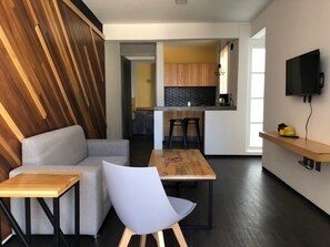 Relax in this inviting space with a sofa, armchair, and TV, perfect for unwinding and dining.