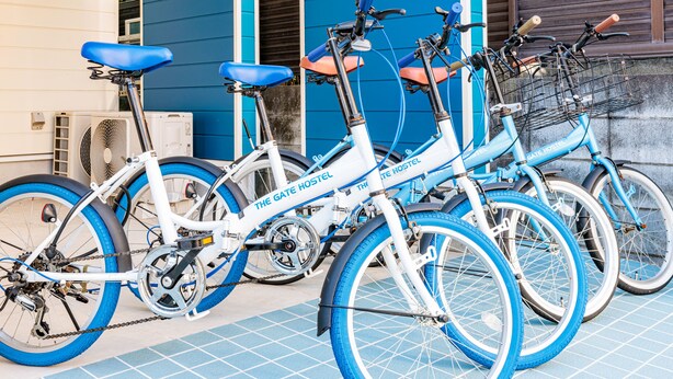 A row of bicycles parked in front of a building with a blue exterior. - The Gate Hostel Shonan Fujisawa (Fujisawa)