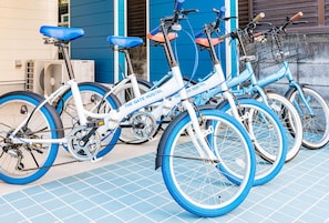 Uma fileira de bicicletas estacionadas em frente a um edifício com fachada azul.