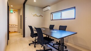A conference room with a long table, four chairs, and a window with blinds. - The Gate Hostel Shonan Fujisawa (Fujisawa)