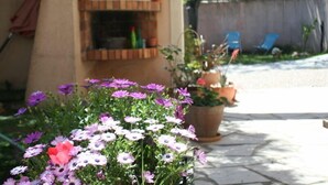 A patio area with potted plants and a brick fireplace. - 2 Chambres Tramontane et Alizé (Jonquerettes)