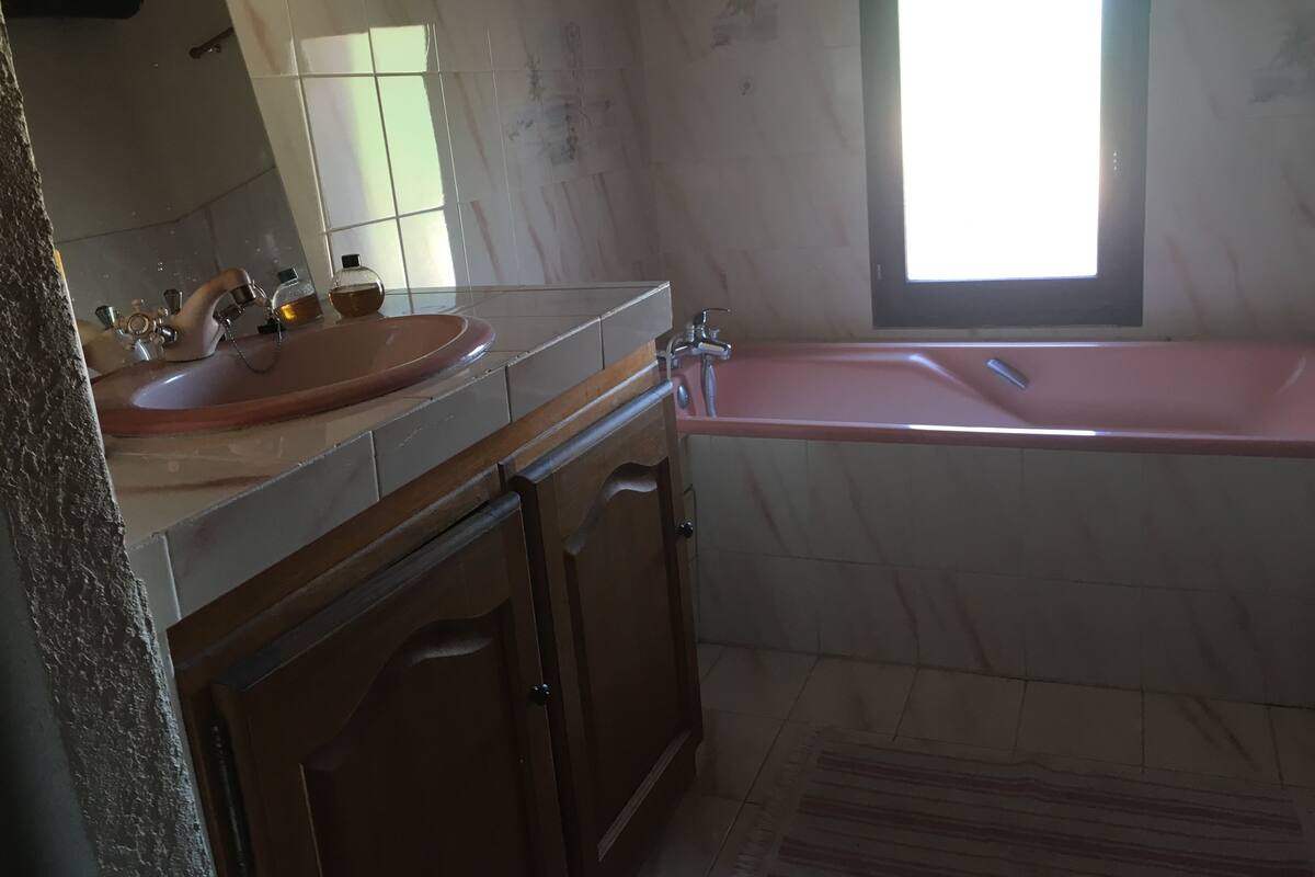 A bathroom with a sink, mirror, vanity, and a bathtub.