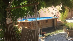 A hammock suspended from a wooden structure, a swimming pool, and a stone patio. - 2 Chambres Tramontane et Alizé (Jonquerettes)
