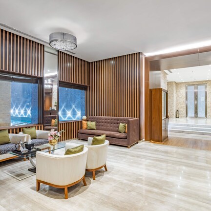 A modern lobby with a seating area, a reception desk, and a view of the pool.
