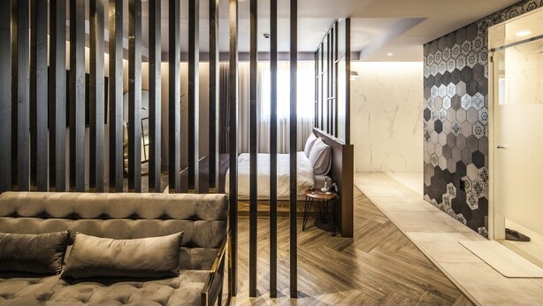 A modern hotel room with a sofa, a bed, a decorative wall, and a sliding door. - Hotel Crape Gyeongsan (Gyeongsan)